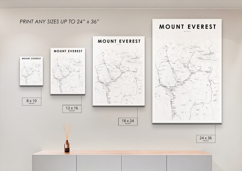Pu&ograve; includere: Quattro stampe incorniciate di una mappa del Monte Everest, Nepal, in diverse dimensioni: 8x10 pollici, 12x16 pollici, 18x24 pollici e 24x36 pollici. Le stampe sono appese a una parete bianca sopra uno scaffale in legno chiaro.