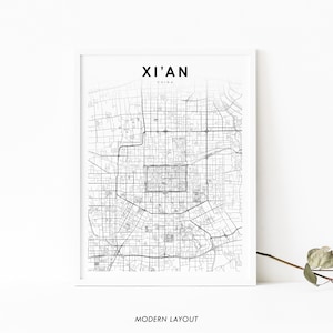 Op de afbeelding: Een ingelijste zwart-wit kaartprint van Xi'an, China. De stadskaart is een gedetailleerde weergave van de straten, met de naam van de stad bovenaan en de tekst "Modern Layout" onderaan.