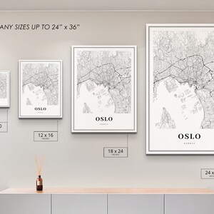 Puede incluir: Cuatro mapas en blanco y negro de Oslo, Noruega, enmarcados, con el nombre de la ciudad y el tama&ntilde;o impresos debajo de cada mapa. Los mapas se muestran en una pared blanca con un estante de madera debajo. Los tama&ntilde;os de los mapas son 8 x 10 pulgadas, 12 x 16 pulgadas, 18 x 24 pulgadas y 24 x 36 pulgadas.