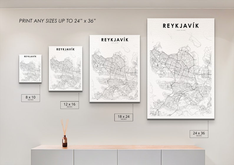 May include: A white wall with four different sizes of black and white city maps of Reykjavik, Iceland. The maps are framed and hanging on the wall. The sizes are 8x10 inches, 12x16 inches, 18x24 inches, and 24x36 inches.