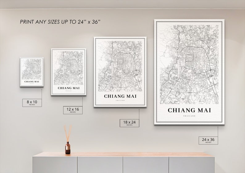 May include: Four different sizes of a black and white map print of Chiang Mai, Thailand. The prints are displayed on a wall with a white background. The sizes are 8x10 inches, 12x16 inches, 18x24 inches, and 24x36 inches.