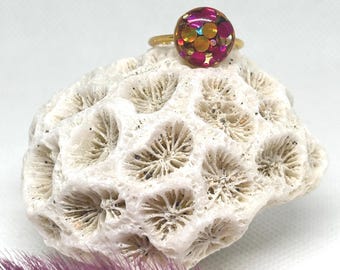 Anillo dorado ajustable con confeti rosa y amarillo.