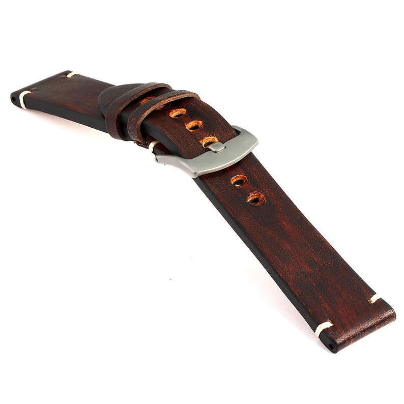 May include: A brown leather watch strap with white stitching and a silver buckle.