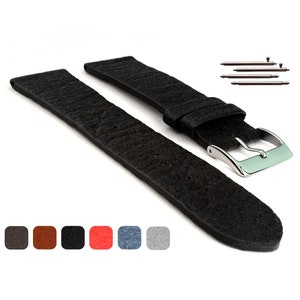 May include: Black leather watch strap with a silver buckle. The strap is made of a textured material and has a smooth finish. The strap is shown with spring bars.