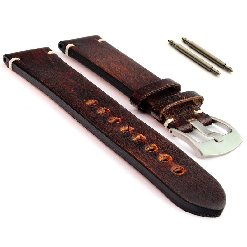 May include: Brown leather watch strap with white stitching and a silver buckle. The strap is distressed and has a vintage look.