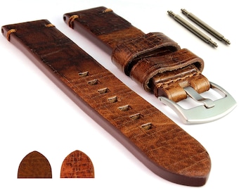 Puede incluir: Correa de reloj de cuero marrón con acabado desgastado y hebilla plateada. La correa tiene un patrón texturizado y está diseñada para un reloj de 20 mm.