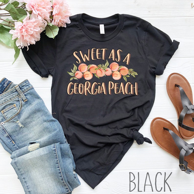May include: Black t-shirt with the text "Sweet as a Georgia Peach" and a graphic of peaches.