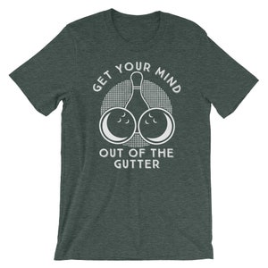 May include: A dark green t-shirt with a white graphic design. The graphic features a bowling pin with two bowling balls on either side of the pin. The text "Get Your Mind Out Of The Gutter" is printed on the shirt.