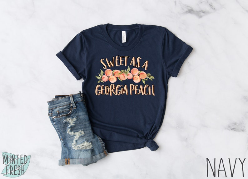 May include: Navy blue t-shirt with a peach graphic and the text "Sweet as a Georgia Peach".