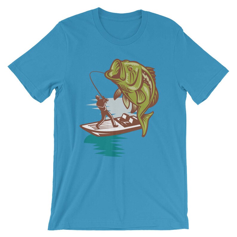 May include: A turquoise blue t-shirt with a graphic of a fisherman in a boat reeling in a large green bass.