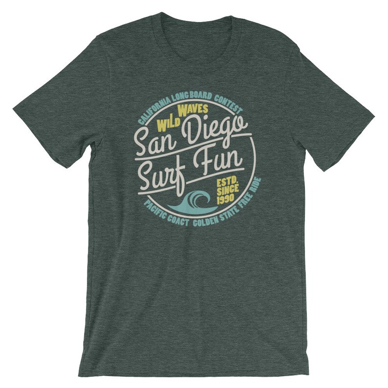 May include: A dark green t-shirt with a vintage-style circular graphic that says "Wild Waves San Diego Surf Fun" with a blue wave graphic and the text "California Longboard Contest Est. Since 1990 Pacific Coast Golden State Free Ride".