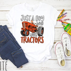 May include: White t-shirt with a red tractor graphic and the text "Just a boy who loves tractors".