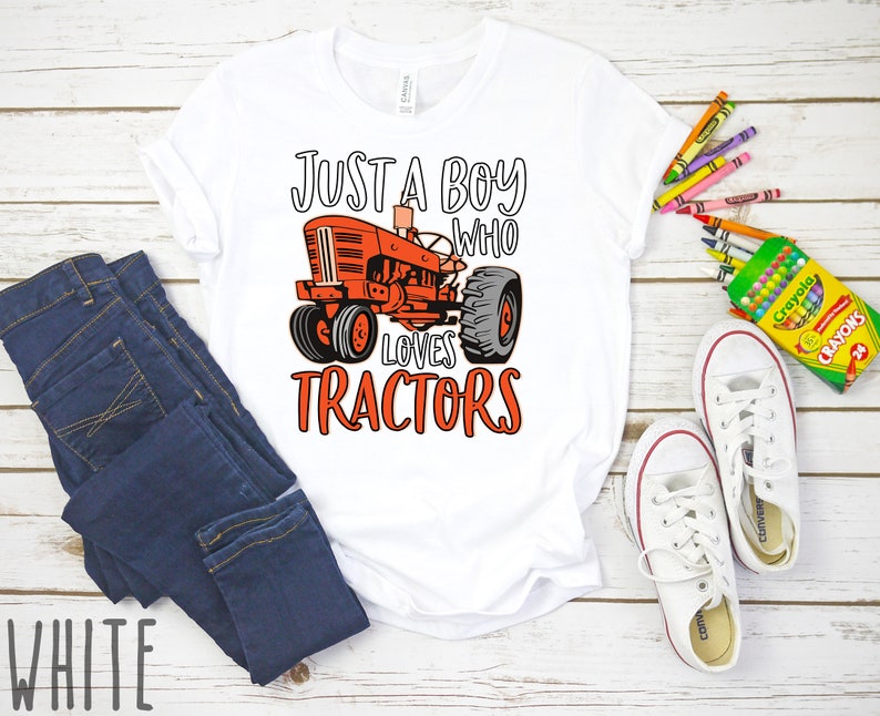 May include: White t-shirt with a red tractor graphic and the text "Just a boy who loves tractors".