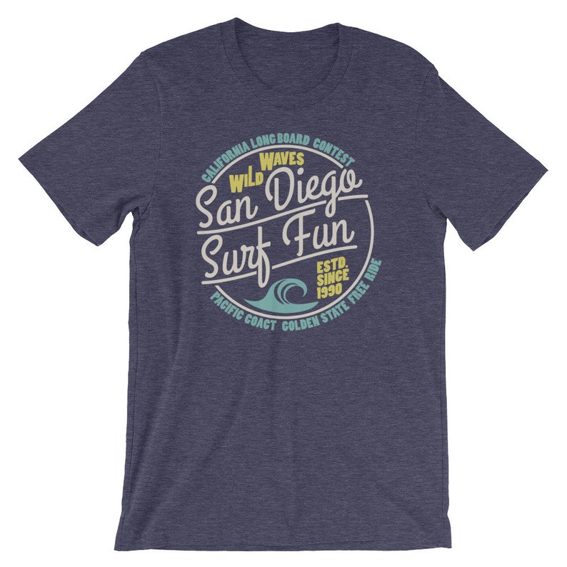 May include: A navy blue t-shirt with a vintage-style graphic of a wave and the text "California Longboard Contest Wild Waves San Diego Surf Fun Est. Since 1990 Pacific Coast Golden State Free Ride".