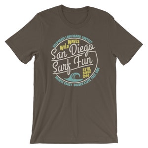 May include: A brown t-shirt with a vintage-style graphic design featuring a wave and the text "California Longboard Contest Wild Waves San Diego Surf Fun Est. Since 1990 Pacific Coast Golden State Free Ride".