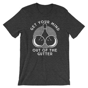May include: Dark heather grey t-shirt with a white graphic of a bowling pin and two bowling balls. The text "Get your mind out of the gutter" is printed on the shirt.