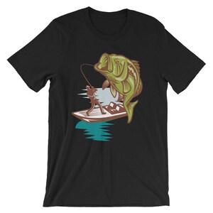May include: A black t-shirt with a graphic of a person fishing from a boat with a large bass jumping out of the water.