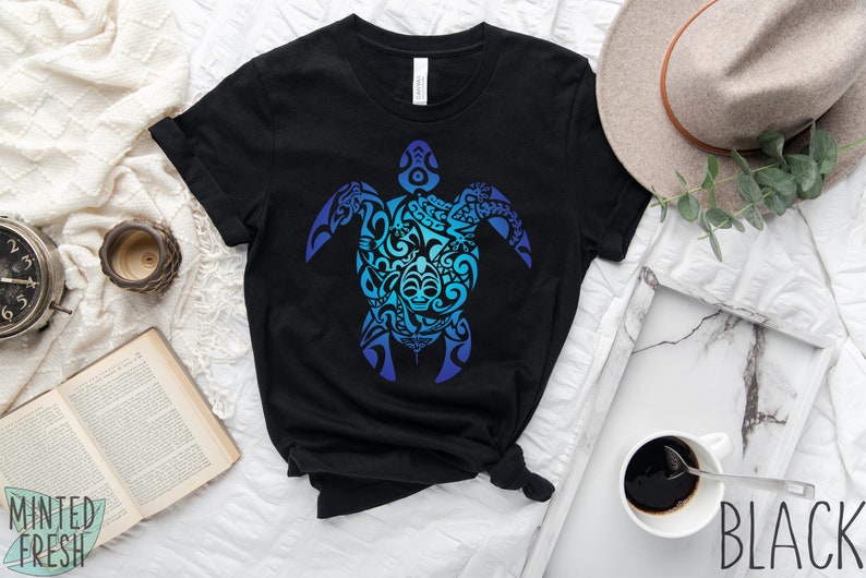 May include: Black t-shirt with a blue and teal gradient design of a stylized turtle with tribal patterns. The design is centered on the shirt.