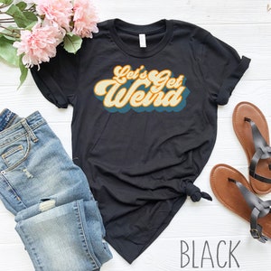 K&ouml;nnte beinhalten: Schwarzes T-Shirt mit einem Retro-Grafikdruck, der "Let's Get Weird" sagt.