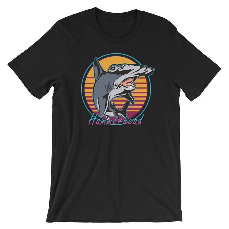 Puede incluir: Camiseta negra con un gr&aacute;fico retro de un tibur&oacute;n martillo en una puesta de sol. El texto "Hammerhead" est&aacute; impreso debajo del tibur&oacute;n.