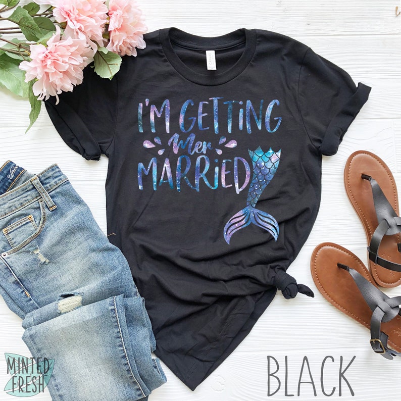 Peut inclure: T-shirt noir avec un graphique de queue de sir&egrave;ne et le texte "I'm getting mer-married".