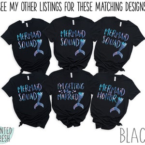 Peut inclure: Six t-shirts noirs avec un motif de queue de sir&egrave;ne et du texte qui dit "Mermaid Squad", "I'm Getting Married", "Mermaid of Honor", et "Mermaid Squad".