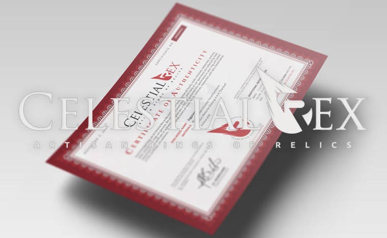 Puede incluir: Un certificado de autenticidad rojo y blanco con el texto "Celestial Rex Artisan Rings of Relics" impreso en la parte superior e inferior.