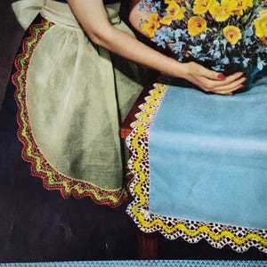 May include: A close-up of a white crocheted lace trim with yellow accents. The trim is shown on a blue surface with the text "S-258" in the bottom right corner.