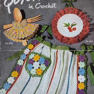 May include: A vintage crochet pattern book cover featuring a crocheted apron with a pocket, a crocheted doily with cherries, and a crocheted spoon holder. The book title is "Quick Tricks in Crochet" and the book number is 267.