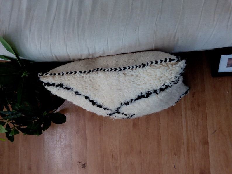 May include: White throw pillow with a black geometric pattern. The pillow is made of a fluffy, textured fabric.