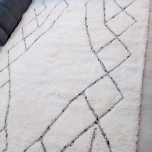 May include: White shag rug with a geometric pattern in black. The pattern is made up of squares and diamonds.