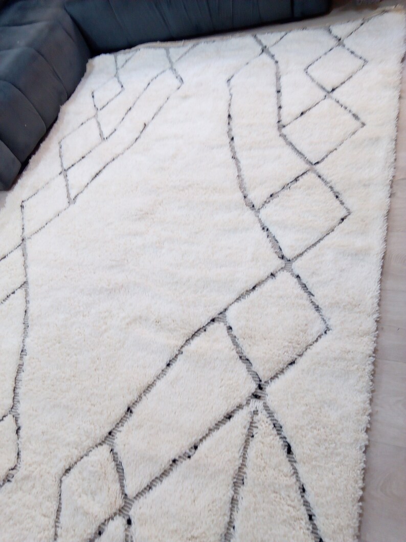 May include: White shag rug with a geometric pattern in black. The pattern is made up of squares and diamonds.