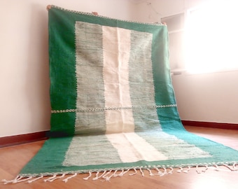 Pode incluir: Um tapete listrado verde e branco com uma borda de franjas. O tapete é tecido com um fio grosso e texturizado.