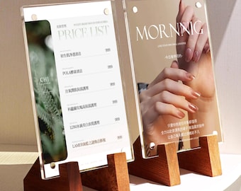 May include: Two clear acrylic display stands with wooden bases. One displays a price list with Chinese characters, the other features the word "MORNNIG" and a hand with manicured nails. The stands are on a white surface.