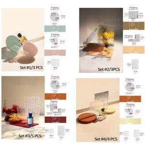 May include: Four sets of decorative display stands for showcasing products. Each set includes a variety of sizes and shapes, with a textured glass panel and a choice of light pink, light blue, or brown bases. The stands are labeled with measurements in centimeters and inches.  Set #1/3 PCS, Set #2/3PCS, Set #3/5 PCS, Set #4/4 PCS.
