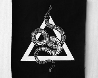 黒いキャンバス地に白いインクでスクリーンプリントされたパッチ「Serpent」