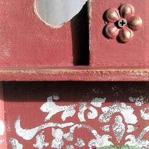 May include: A red wooden clock with a white floral design and a clock face that says "Cardova Watch".