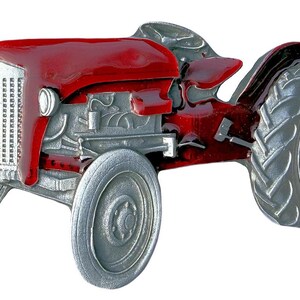 May include: A red and silver toy tractor with a detailed engine and wheels. The tractor is made of metal and has a realistic design.