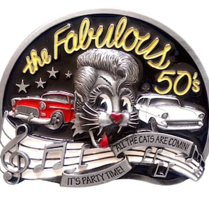 May include: A silver belt buckle with a black background featuring a cartoon cat with a pompadour hairstyle. The buckle says "The Fabulous 50's" and "All the cats are comin' It's party time!" with musical notes.