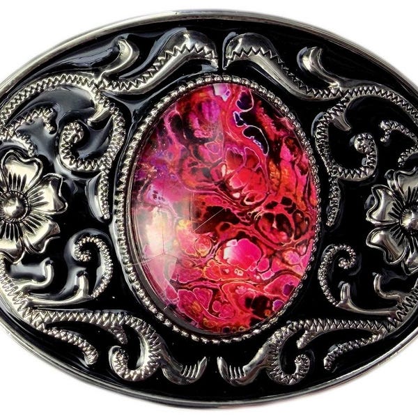 Könnte beinhalten: Eine ovale Gürtelschnalle mit einem zentralen Cabochon in marmoriertem Pink, Rot und Schwarz. Der silberfarbene Metallrahmen ist mit geprägten Blumenmotiven und Ranken auf einem glänzend schwarzen Emaillehintergrund verziert.