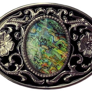 May include: Oval-shaped belt buckle with a black enamel background and silver-colored filigree. The center features an oval abalone shell design with green, blue, and yellow hues. Two floral accents are on each side of the buckle.