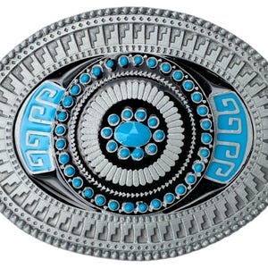 Könnte beinhalten: Eine silberfarbene Gürtelschnalle mit einem blauen und schwarzen Design. Die Schnalle zeigt ein kreisförmiges Muster mit türkisfarbenen Steinen und einem geometrischen Rand.