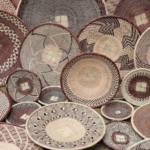 May include: A collection of woven baskets in various sizes and patterns. The baskets are made of natural materials and have a brown and beige color scheme.