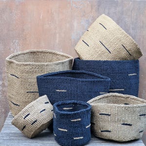 Puede incluir: Un conjunto de seis cestas tejidas de diferentes tamaños. Las cestas están hechas de materiales naturales y tienen un esquema de color negro y natural. Las cestas son perfectas para almacenamiento o exhibición.