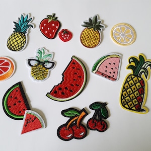 May include: Assortment of colorful embroidered iron-on patches featuring various fruits, including pineapples, strawberries, lemons, watermelons, cherries, and a grapefruit.