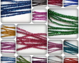 Può includere: Assortimento di puliscipipe colorati e glitterati. I puliscipipe sono disposti in file e sono disponibili in una varietà di colori, tra cui blu, verde, rosso, oro, argento e viola.