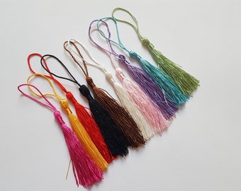 May include: Assortment of ten colorful tassels with a variety of colors including pink, purple, blue, green, brown, black, red, yellow, and gold.