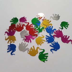 May include: Assortment of colorful metallic elephant-shaped confetti. The confetti is made of shiny, reflective material and comes in a variety of colors, including silver, gold, green, blue, red, and pink.