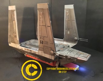 May include: A grey and silver model of a Star Wars V-4X-D ski speeder with a red light on the bottom. The model is on a black surface. COPYRIGHT BIGBANGCOLLECTABLES ON ETSY