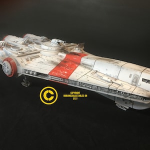 May include: A white and red spaceship model with a weathered look. The model has a long, narrow body with three engines at the rear. The model is sitting on a black surface. COPYRIGHT BIGBANECOLLECTABLES ON ETSY